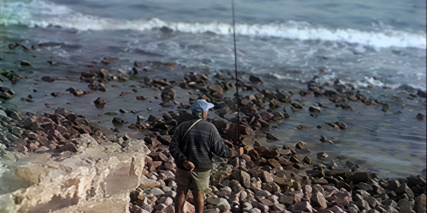 Image restaurée d’un pêcheur au bord de la mer